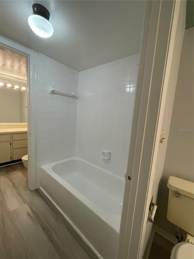 full bathroom featuring vanity, shower / washtub combination, hardwood / wood-style flooring, and toilet