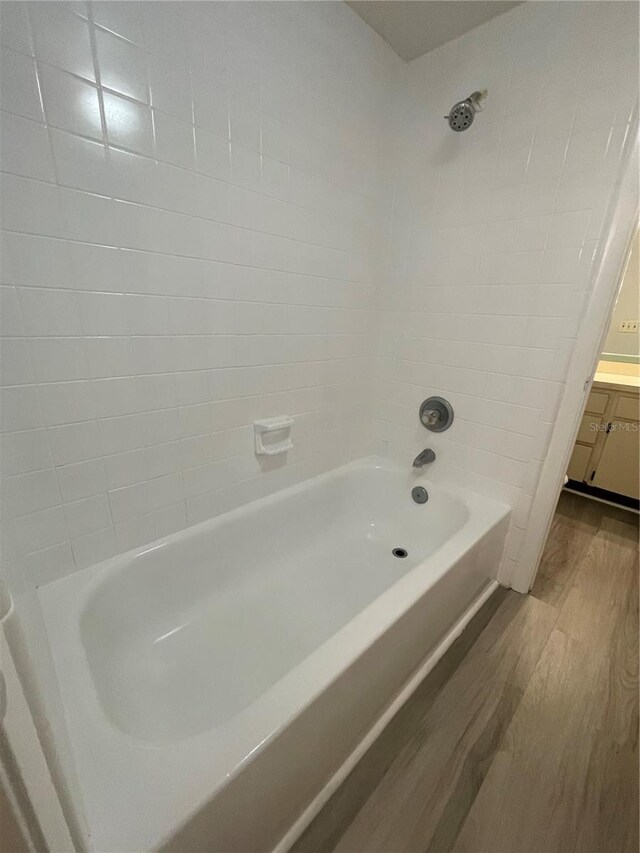 bathroom featuring vanity, tiled shower / bath, and wood-type flooring