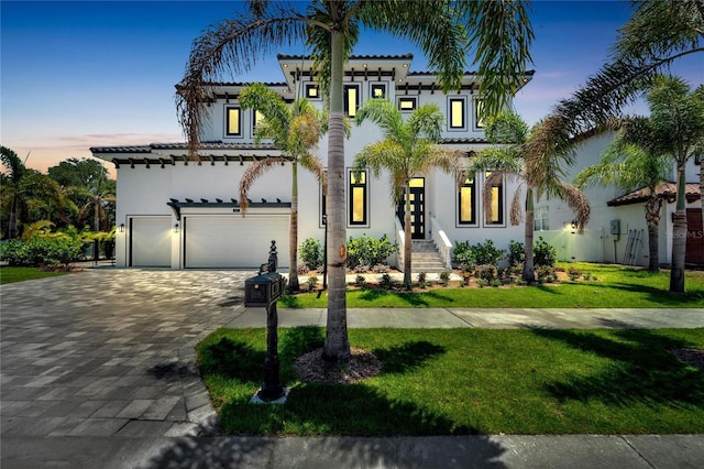 mediterranean / spanish-style house with a garage and a yard