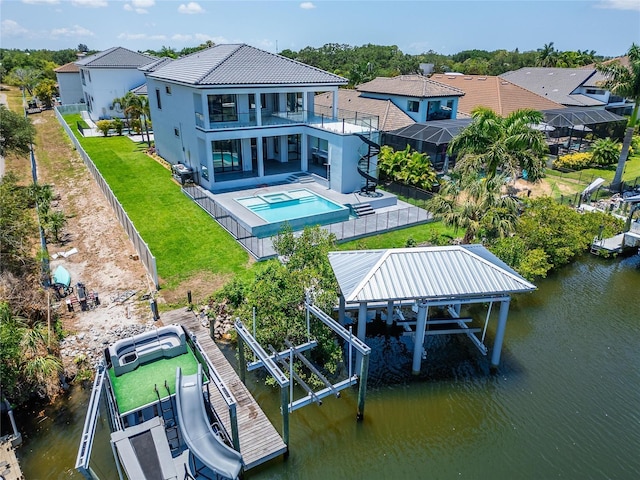 rear view of house with a balcony, a fenced in pool, a water view, and a patio