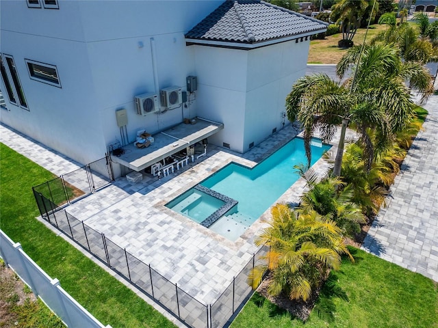 view of swimming pool featuring an in ground hot tub, ac unit, exterior bar, and a lawn