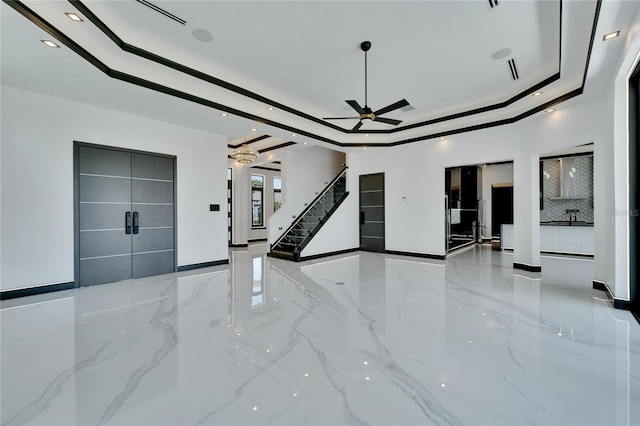 living room with a raised ceiling and ceiling fan