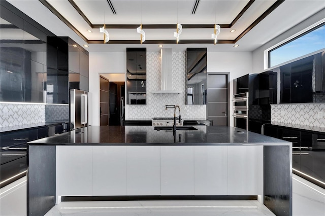 kitchen featuring stainless steel appliances, tasteful backsplash, a large island, and sink