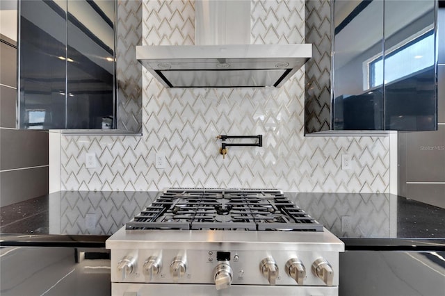 kitchen with range hood, decorative backsplash, range, and dark stone counters