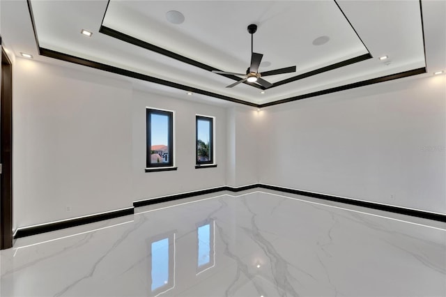 empty room with ceiling fan, crown molding, and a tray ceiling