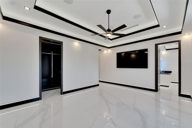 unfurnished room with a raised ceiling, tile walls, and ceiling fan