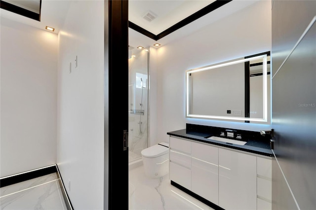 bathroom featuring toilet, a shower with shower door, and vanity