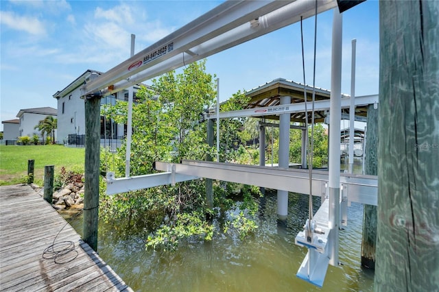 view of dock with a water view and a yard