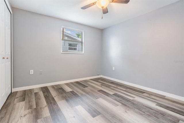 unfurnished bedroom with ceiling fan, hardwood / wood-style floors, and a closet