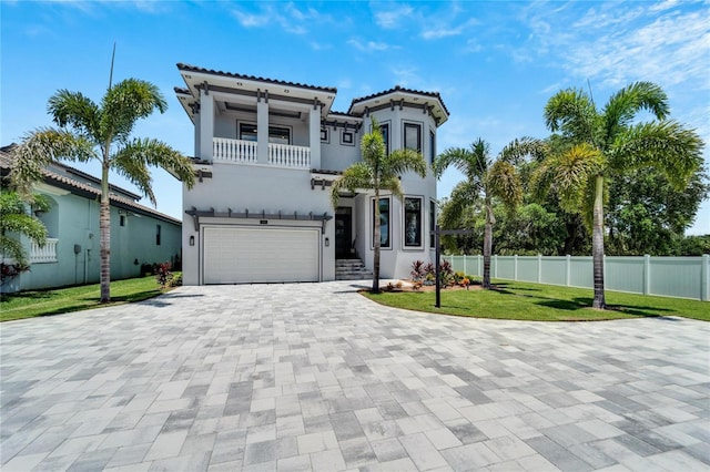 mediterranean / spanish home featuring a front yard, a garage, and a balcony