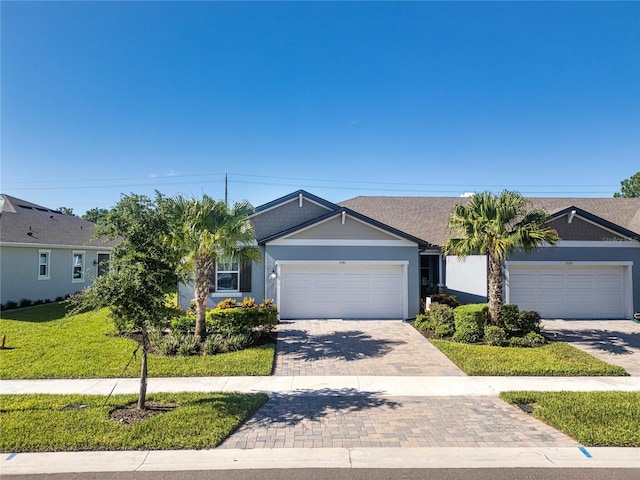 single story home with a garage and a front lawn