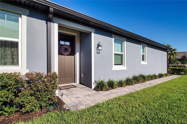 property entrance featuring a lawn