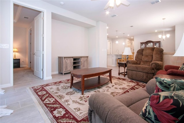 tiled living room featuring ceiling fan with notable chandelier