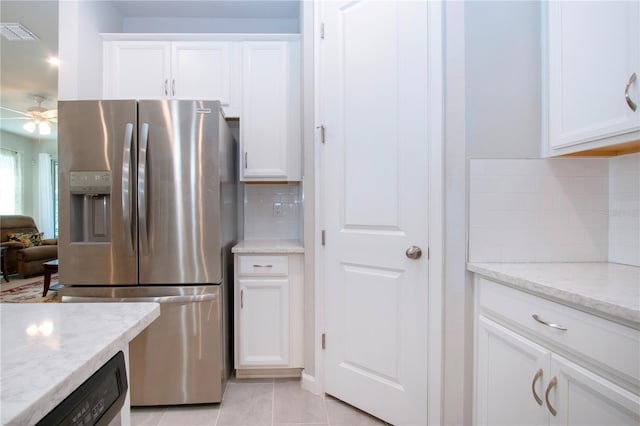 kitchen featuring light stone countertops, white cabinetry, tasteful backsplash, stainless steel fridge with ice dispenser, and light tile patterned flooring