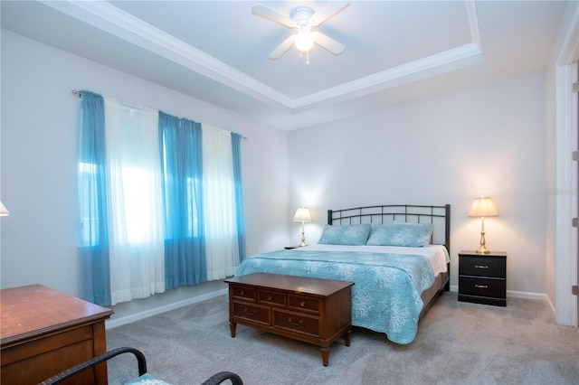 bedroom with ceiling fan, light carpet, and a raised ceiling