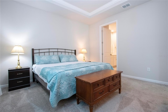 bedroom featuring ensuite bathroom, carpet flooring, and a raised ceiling