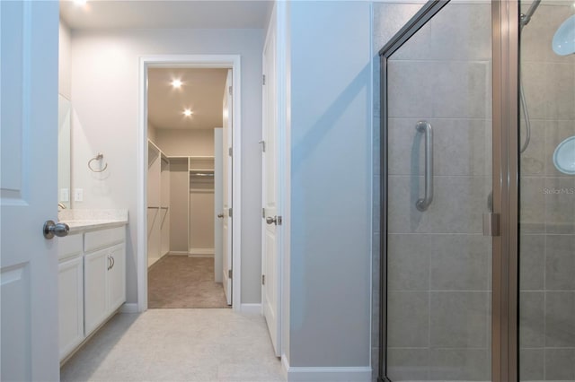 bathroom featuring a shower with door, tile patterned floors, and vanity