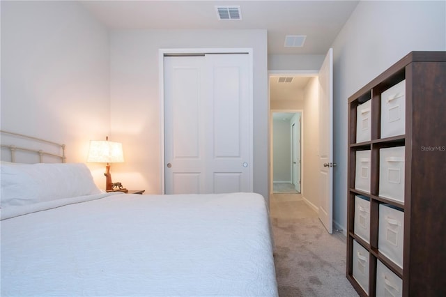 bedroom featuring light colored carpet and a closet