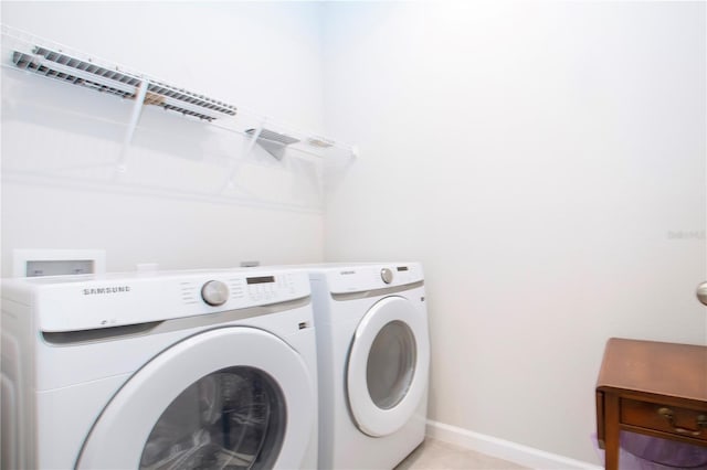 laundry room with light tile patterned floors and washing machine and dryer