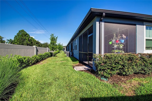 view of yard with central AC unit and a sunroom