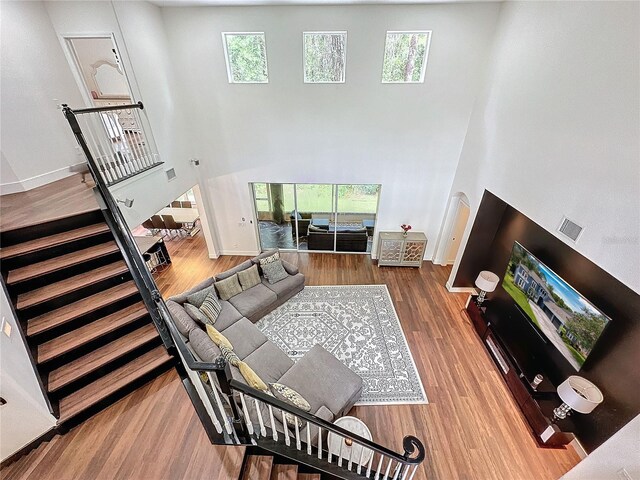 living room with wood-type flooring and a high ceiling