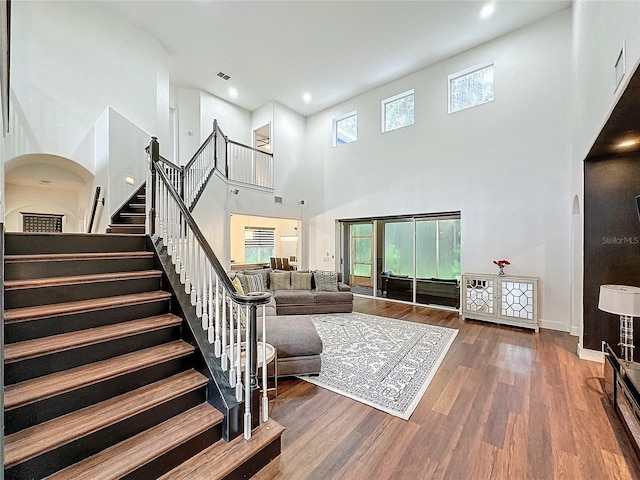 living room featuring dark hardwood / wood-style flooring and a towering ceiling