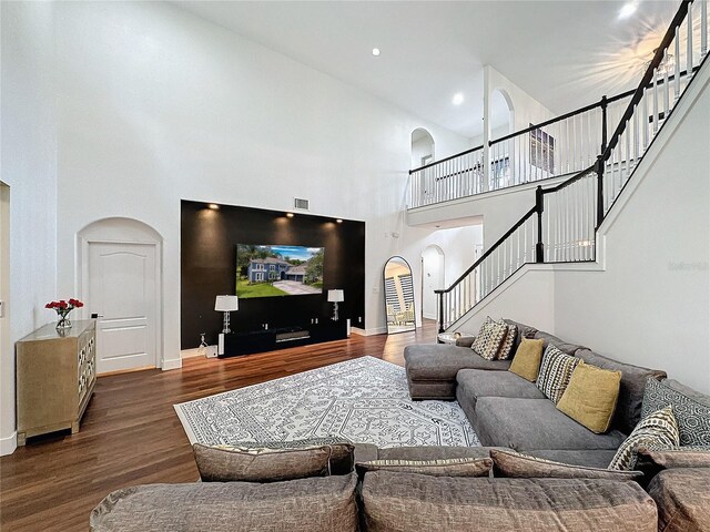 living room featuring a towering ceiling and wood-type flooring