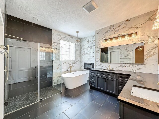 bathroom with shower with separate bathtub, tile patterned floors, and tile walls