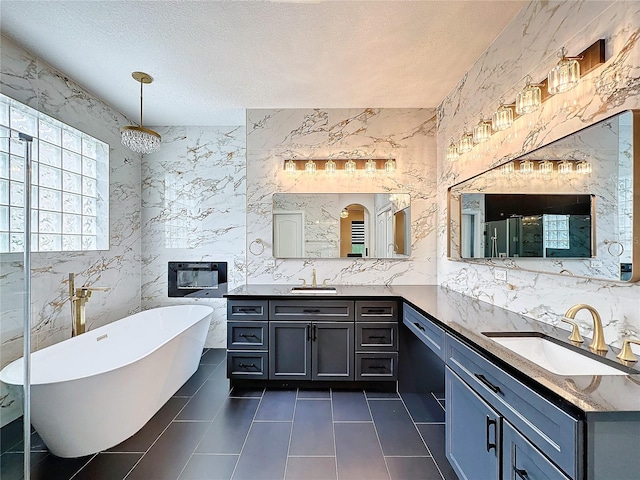 bathroom with a textured ceiling, tile patterned flooring, tile walls, and dual bowl vanity