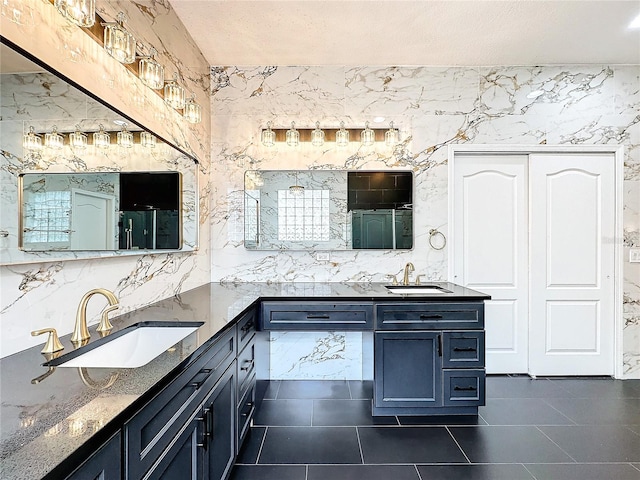 bathroom featuring double vanity, tile patterned floors, and a textured ceiling