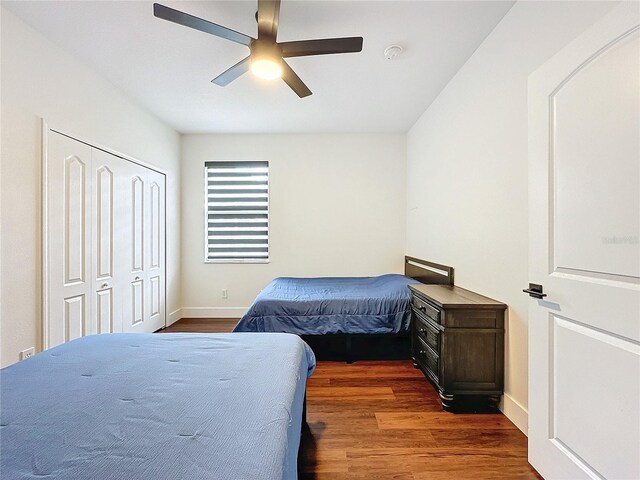 bedroom featuring dark wood-type flooring, ceiling fan, and a closet