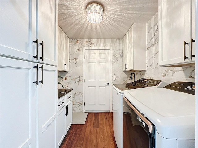 kitchen with white cabinetry, a textured ceiling, independent washer and dryer, and hardwood / wood-style floors