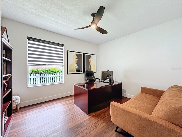 home office featuring wood-type flooring, a textured ceiling, and ceiling fan