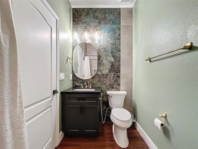 bathroom with hardwood / wood-style flooring, toilet, vanity, and tile walls