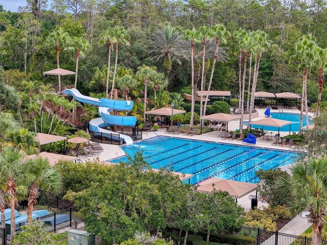 view of pool with a water slide and a patio area