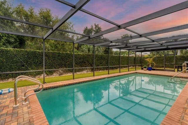 pool at dusk with a lanai