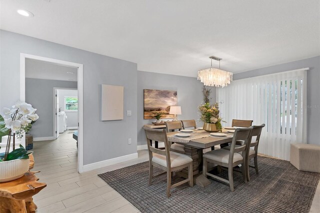 dining space with hardwood / wood-style flooring and a notable chandelier