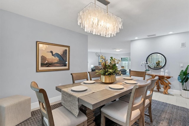 dining area featuring an inviting chandelier, baseboards, and visible vents