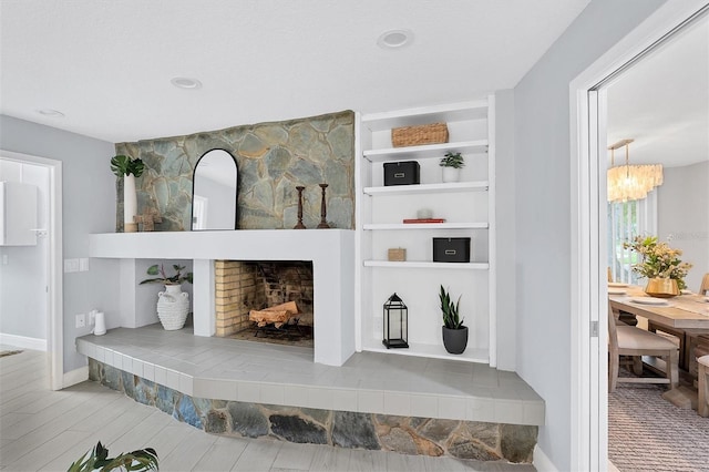 details featuring a fireplace, built in shelves, and wood-type flooring