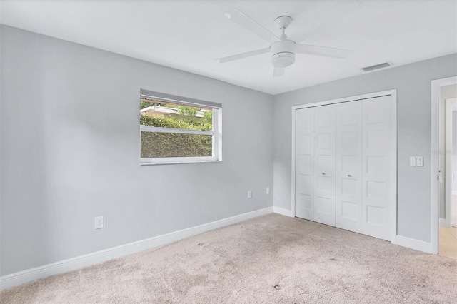 unfurnished bedroom with light carpet, a closet, and ceiling fan