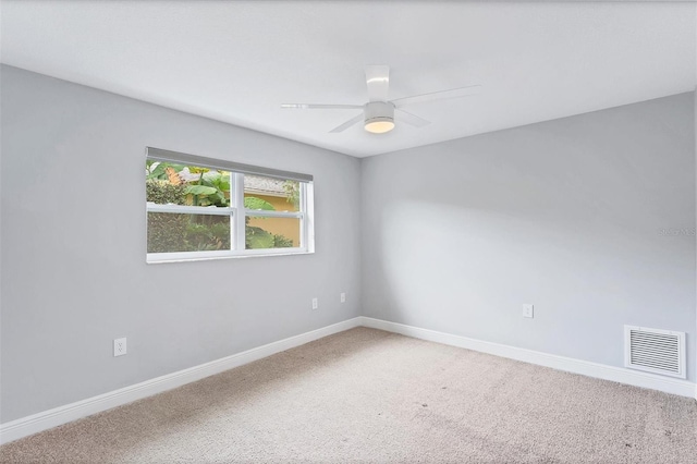 spare room featuring ceiling fan, carpet, visible vents, and baseboards