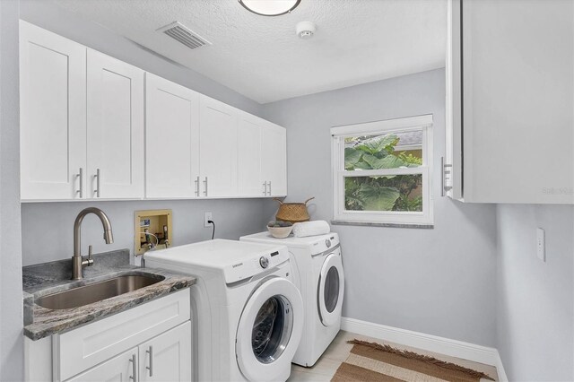 laundry room featuring cabinets, washer and dryer, and sink