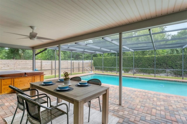 view of swimming pool with a patio area, a hot tub, ceiling fan, and glass enclosure