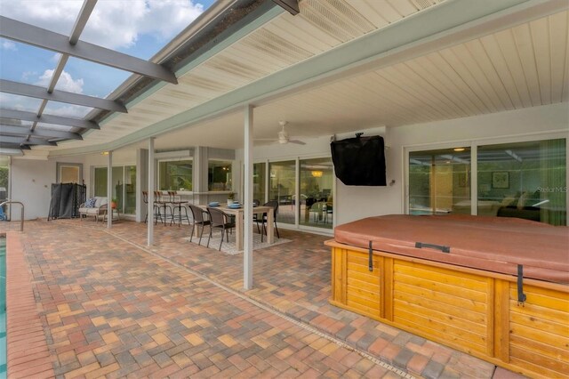 view of patio / terrace with ceiling fan and a hot tub