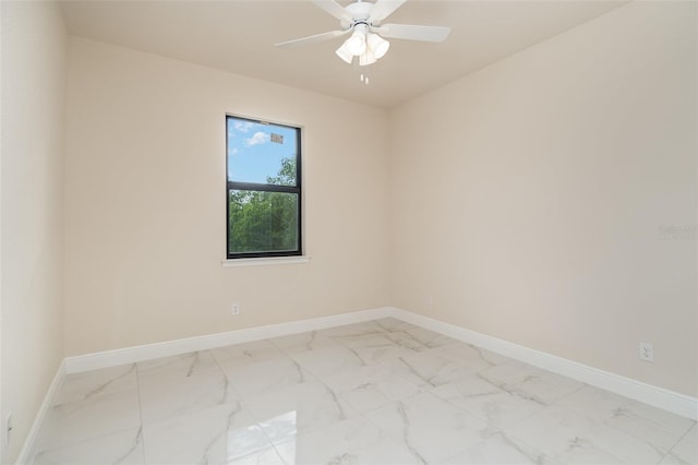 unfurnished room featuring marble finish floor, baseboards, and a ceiling fan