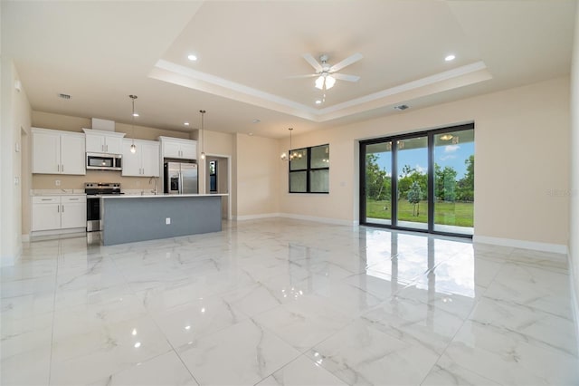 unfurnished living room featuring marble finish floor, baseboards, and a tray ceiling