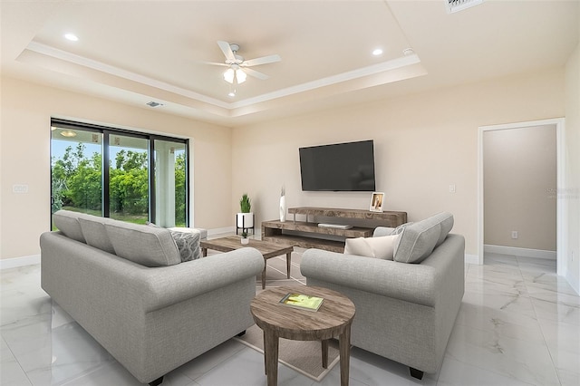 living room featuring ceiling fan and a tray ceiling