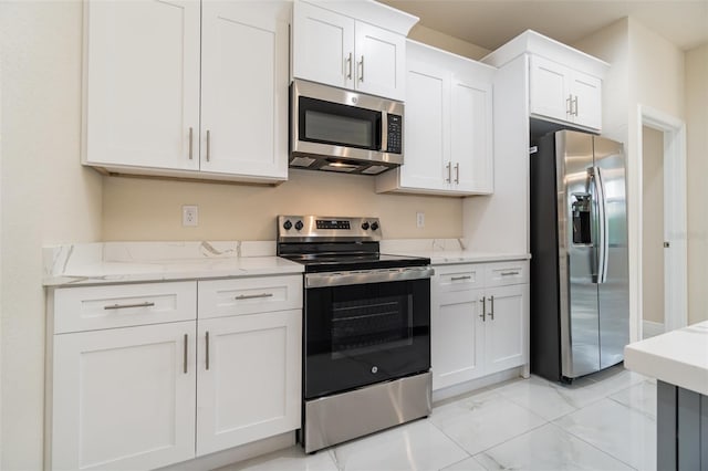 kitchen featuring light stone countertops, white cabinetry, appliances with stainless steel finishes, and marble finish floor