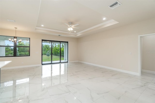 spare room featuring crown molding, a tray ceiling, and ceiling fan with notable chandelier