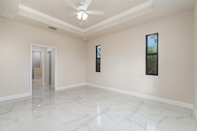 empty room featuring baseboards, visible vents, ornamental molding, marble finish floor, and a tray ceiling